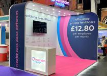 Benenden Health stand, 2 walls, arched, angled roof with downlight, and lightbox counter