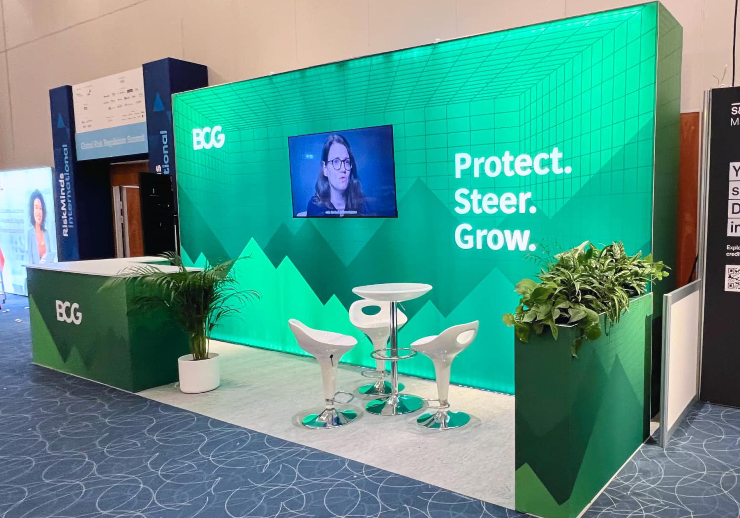 Big exhibition stand, single lightbox wall, L-shape counter and plant-topped plinth