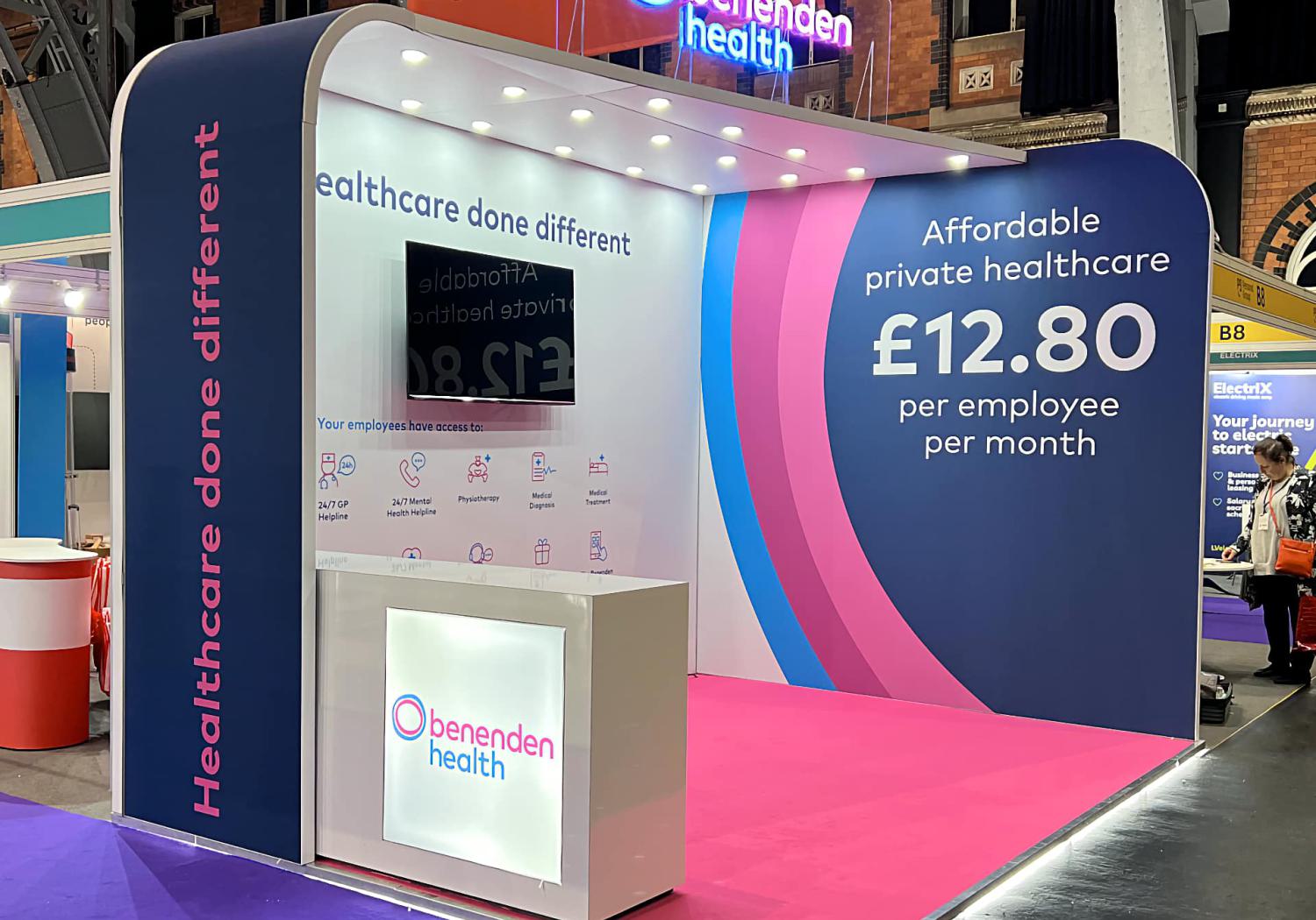 Benenden Health stand, 2 walls, arched, angled roof with downlight, and lightbox counter