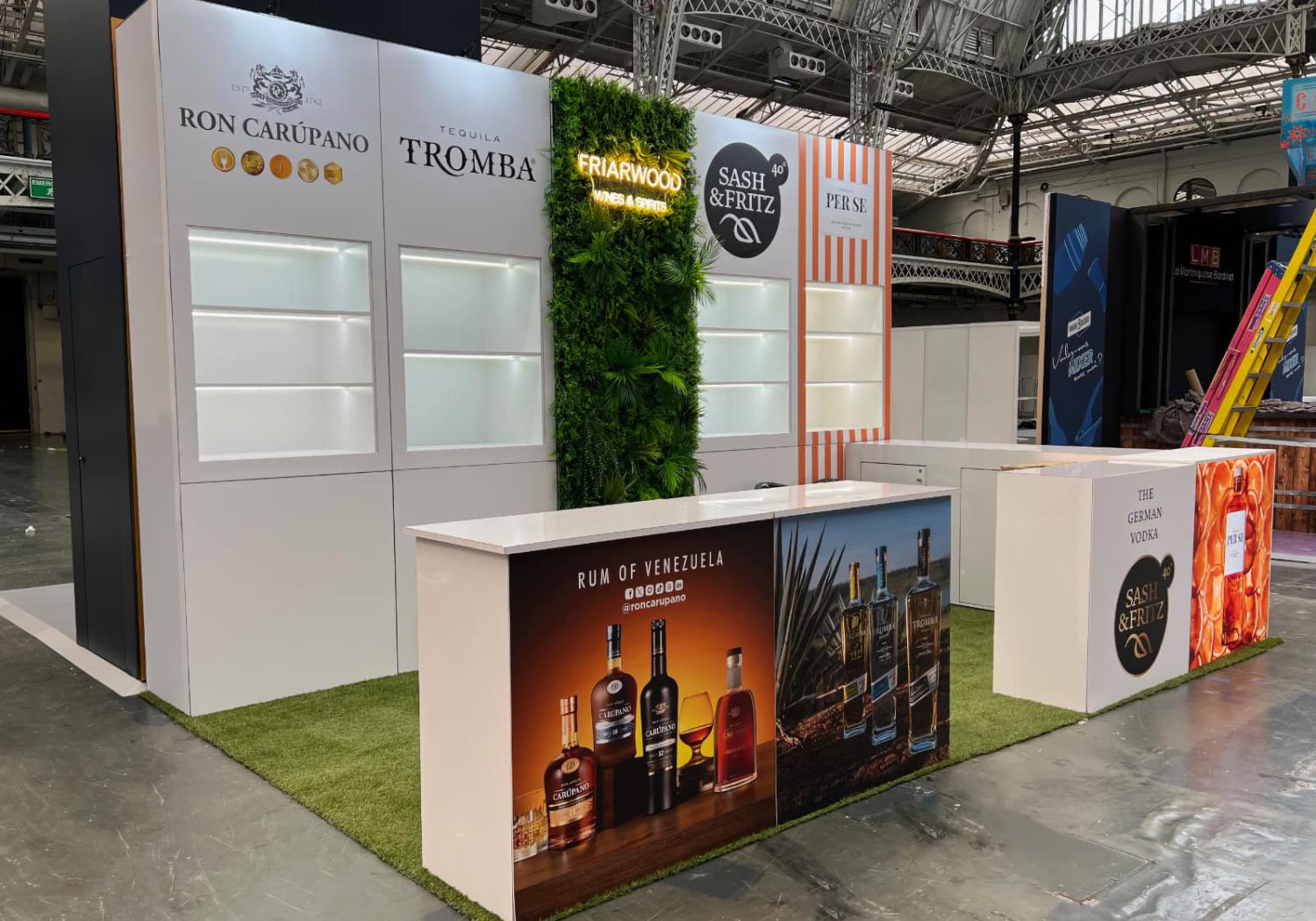 Friarwood exhibition stand, back wall with artificial shrubbery on back wall and neon lighting